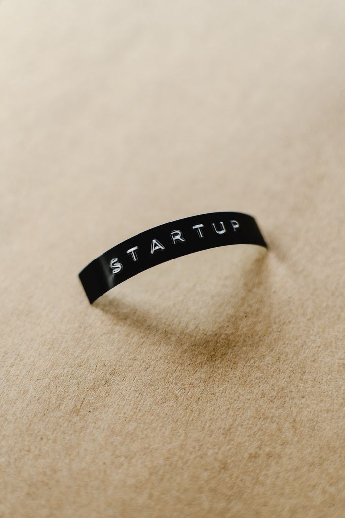 Close-up of a black label with STARTUP text on a beige background, perfect for conceptual business themes.